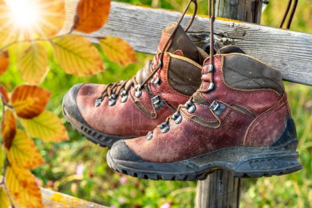 Photo for Hiking boots hanging on a bench in autumn - Royalty Free Image