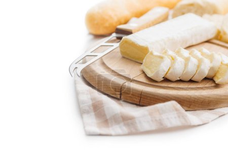 Artfully arranged cheese on wooden board with cloth and knife, highlighting the art of food presentation