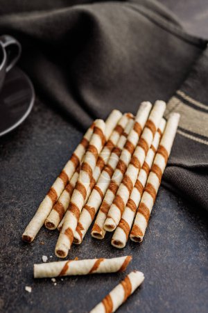 Delicious Striped Wafer Rolls on a dark table.