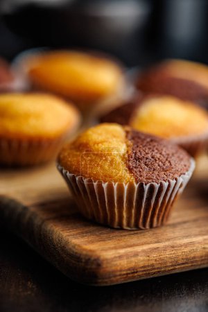 Close Up of a Muffins on cutting board on a black table.