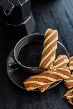 Classic Striped Cookies and coffee cup on a black table.