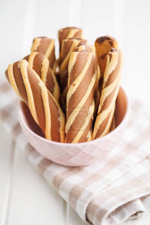 Classic Striped Cookies in bowl on a white table.
