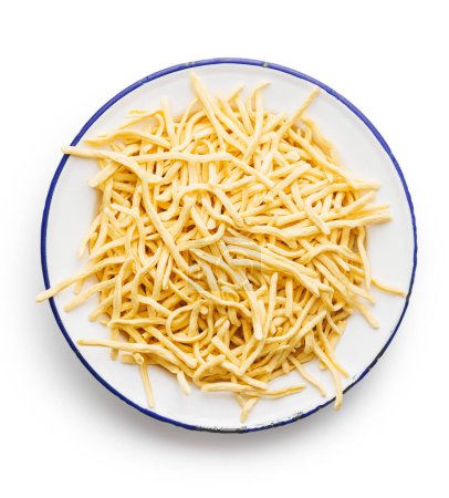 Uncooked spaetzle pasta on plate isolated on a white background.  
