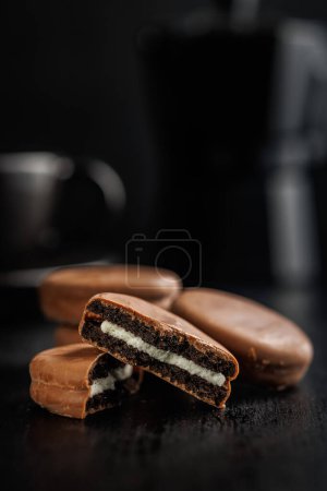 Vue rapprochée des biscuits sandwich enrobés de chocolat sur fond sombre