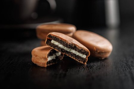 Close-Up View of Chocolate-Coated Sandwich Cookies on a Dark Background