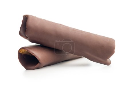 Rollos de oblea cubiertos de chocolate apilados uno encima del otro sobre un fondo blanco. Los rollos son de color marrón claro y están cubiertos con una fina capa de chocolate negro. Los rollos de oblea son ligeramente curvados y tienen una textura crujiente.