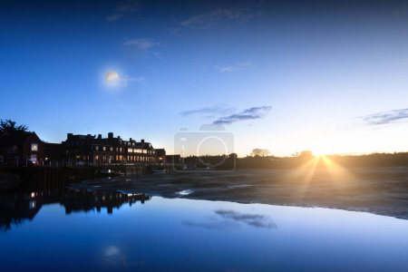Photo for Blakeney Quay skyline in Norfolk England blue light at dusk and still water with low tide - Royalty Free Image