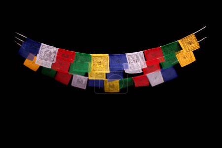 Téléchargez les photos : Drapeaux de prière tibétains isolés sur fond noir - en image libre de droit
