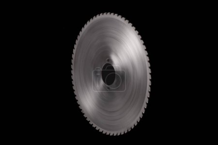 Photo for Spinning giant circular saw blade with big cutting teeth isolated on a black backgroun - Royalty Free Image