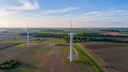 Téléchargez les photos : Drone d'éoliennes tourné d'en haut dans les champs agricoles ruraux de Norfolk au Royaume-Uni pendant la soirée de coucher du soleil - en image libre de droit