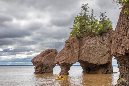 Kayak at The flowerpot rock formations at Hopewell Rocks, Bay of Fundy, New Brunswick. El rango de marea extrema de la bahía hace que solo sean accesibles con marea baja.