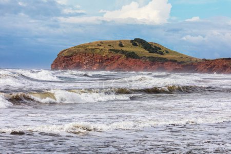 The colourful sandstone cliffs and choppy seas of Havre Aubert, Magdalen Islands, Quebec Province, Canada.