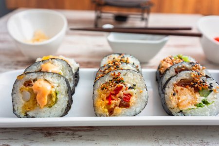 Foto de Set de sushi colorido con palillos en el plato - Imagen libre de derechos