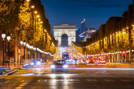 Avenue des Champs-Elysees i Łuk Triumfalny o zmierzchu w Paryżu. Francja