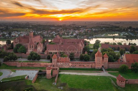 Téléchargez les photos : Le Château de l'Ordre Teutonique à Malbork au bord de la rivière Nogat au coucher du soleil. Pologne - en image libre de droit