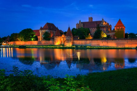 Photo for The Castle of the Teutonic Order in Malbork by the Nogat river at dusk. Poland - Royalty Free Image