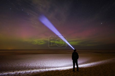 Téléchargez les photos : Un homme observant les aurores boréales sur la plage de la mer Baltique à Sztutowo. Pologne - en image libre de droit
