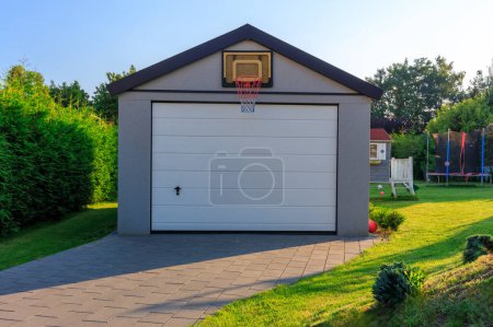 Téléchargez les photos : Garage indépendant dans un jardin verdoyant en été - en image libre de droit