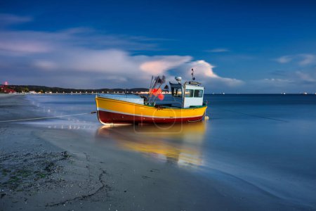Téléchargez les photos : Bateaux de pêche sur la plage de la mer Baltique à Sopot au crépuscule, Pologne - en image libre de droit