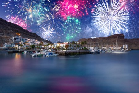 Téléchargez les photos : Exposition de feux d'artifice du Nouvel An sur la ville de Puerto de Mogan, Gran Canaria. Espagne. - en image libre de droit