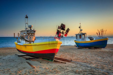 Téléchargez les photos : Bateaux de pêche sur la plage de la mer Baltique à Sopot au lever du soleil, Pologne - en image libre de droit