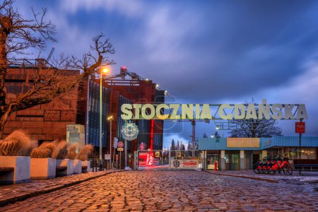 Téléchargez les photos : Gdansk, Pologne - 11 janvier 2024 : Porte historique du chantier naval de Gdansk et du monument des trois croix sur la place européenne de la solidarité à Gdansk. Pologne - en image libre de droit