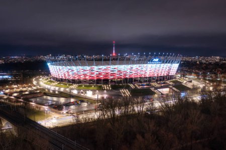 Téléchargez les photos : Warszawa, Pologne - 27 janvier 2024 : Le stade national de Varsovie illuminé dans les couleurs nationales de la Pologne la nuit. - en image libre de droit