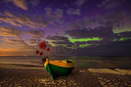Téléchargez les photos : Aurores boréales sur la mer Baltique sur la plage de Jantar avec des bateaux de pêche, Pologne. - en image libre de droit