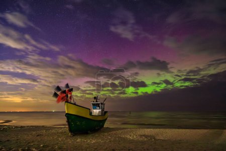 Téléchargez les photos : Aurores boréales sur la mer Baltique sur la plage de Jantar avec des bateaux de pêche, Pologne. - en image libre de droit