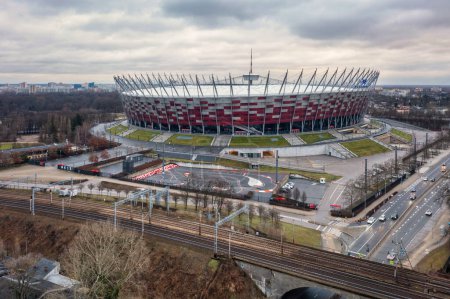 Foto de Warszawa, Polonia - 27 de enero de 2024: El Estadio Nacional de Varsovia iluminado en los colores nacionales de Polonia en el día nublado. - Imagen libre de derechos
