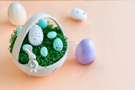 Foto de Cesta de porcelana con berro y huevos de Pascua sobre fondo pastel - Imagen libre de derechos