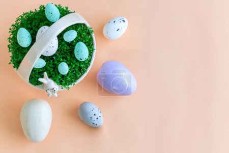 Téléchargez les photos : Panier en porcelaine avec cresson et œufs de Pâques sur fond pastel - en image libre de droit