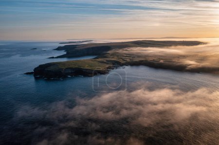 Misty sunrise over the rocky coast of Kilkee, Co. Clare. Irlanda