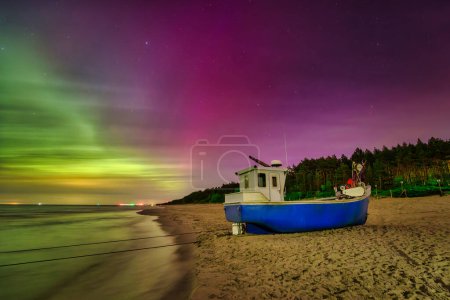 Téléchargez les photos : Aurora sur la mer Baltique sur la plage de Katy Rybackie avec bateau de pêche en Pologne. - en image libre de droit