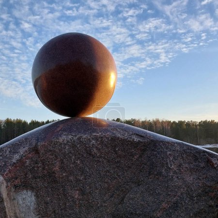 Photo for Granite sculpture. A huge round stone miraculously keeps balance. Modern Art. A fragile balance. - Royalty Free Image