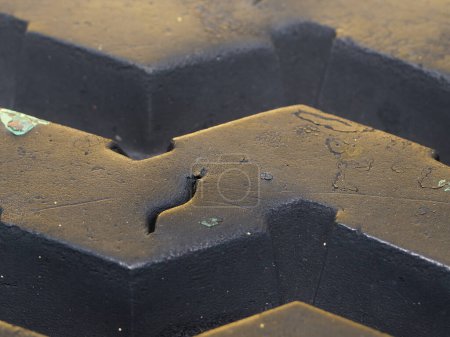 Dans cette photographie détaillée en gros plan, les textures et les motifs complexes de la surface en caoutchouc d'un pneu sont mis en évidence.