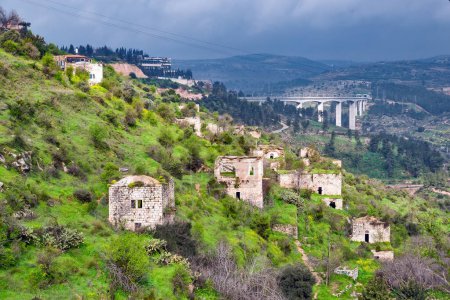 Photo for Lifta, an abandoned Arab village against the backdrop of the railway bridge at the entrance to Jerusalem. - Royalty Free Image