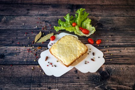 Foto de Croque monsieur a la parrilla con queso fundido servido sobre una base de madera - Imagen libre de derechos