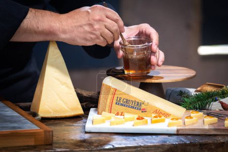 Foto de 12 de julio de 2022, Lyon, Francia: Degustado famoso queso suizo: Le Gruyere d 'Alpage con miel para el almuerzo y la experiencia gastronómica - Imagen libre de derechos