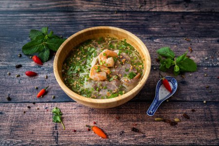 Téléchargez les photos : Spécialité vietnamienne : soupe de raviolis dans un bol et placé sur une table en bois - en image libre de droit