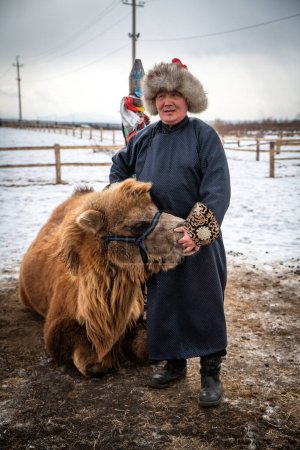 Téléchargez les photos : Zone Naryn-Atsagat, près d'Oulan Oude (ulan ude), Sibérie, Russie - Mars 09, 2020 : Un bouriate en costume traditionnel avec son chameau. - en image libre de droit