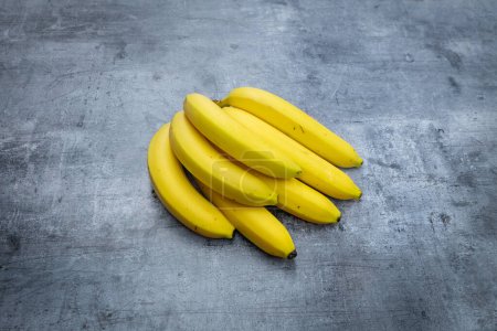 Foto de Cosecha de plátanos frescos sobre un fondo gris - Imagen libre de derechos
