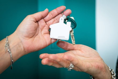 Téléchargez les photos : Deux mains changent les clés après l'achat d'une maison immobilier - en image libre de droit