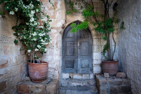Téléchargez les photos : Charmante vieille ville de Lindos dans les îles du Dodécanèse. Vieilles portes et fleurs charmantes. Grèce - en image libre de droit