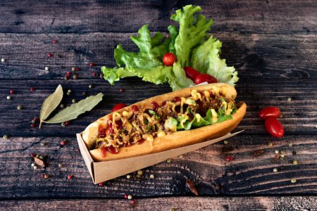 Téléchargez les photos : Hot dog savoureux et chaud sur un fond en bois - en image libre de droit
