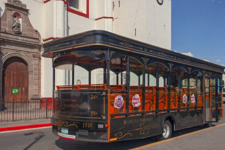 Photo for Cholula, Mexico - March 18, 2022 - The tourist sightseeing  bus parked beside Cathedral in Cholula, Puebla, Mexico. - Royalty Free Image