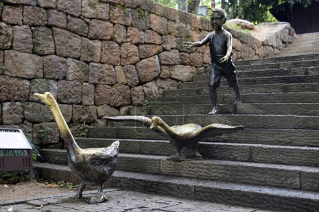 Téléchargez les photos : Zhuji, Zhejiang, Chine - 21 juin 2023 : Le décor du parc natal de Xi Shi et statue de garçon avec des oies oiseaux à Zhuji, province du Zhejiang, Chine - en image libre de droit