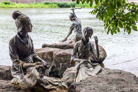 Téléchargez les photos : Zhuji, Zhejiang, Chine - 18 juin 2023 : Le paysage du parc natal de Xi Shi et les statues de femmes sur la rive de la rivière à Zhuji, province du Zhejiang, Chine - en image libre de droit
