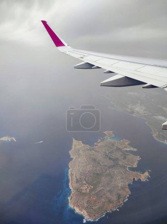Wolken und ein Flügel des Wizzair-Airbusses aus dem Flugzeugfenster. über Maltas Inseln und das Mittelmeer