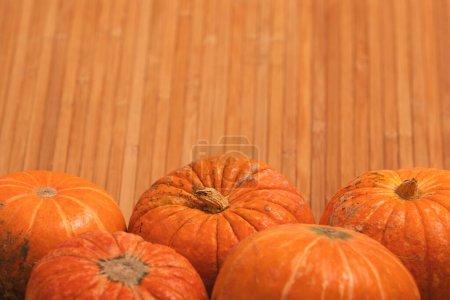 Photo for Autumn orange halloween pumpkins on bamboo planks background. Concept Halloween celebration background, fall harvest, minimalism holiday decoration template. Top view, flat lay, copy space - Royalty Free Image